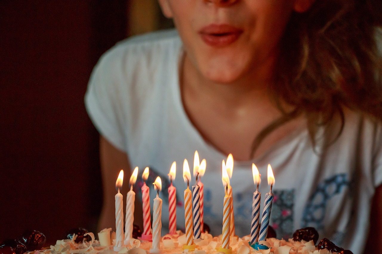 A colorful birthday cake with candles, celebrating a special occasion and symbolizing personal growth and joy.